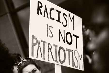 Sign says, "Racism is not patriotism".