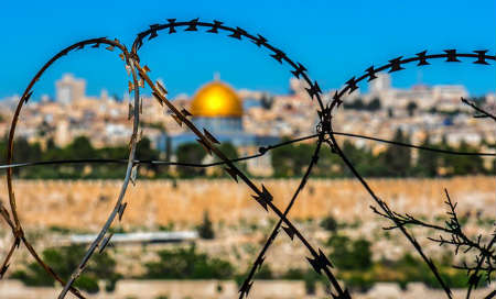 The city of Jerusalem, viewed through a barbed wire fence.