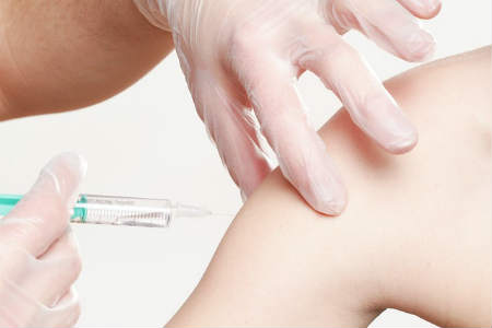 A needle stuck in a child's arm for vaccination purposes.